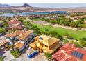Aerial view of home under construction, showcasing the tile roof, solar panels, and surrounding neighborhood near a lake at 8 Rue Du Ville Way, Henderson, NV 89011
