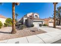 Attractive two-story home boasting a lush front yard, two-car garage and mature palm trees at 8012 Pottery Creek Dr, Las Vegas, NV 89128