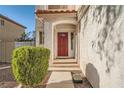 Inviting covered front porch with a red door, exterior light fixture, and gravel landscaping at 8476 Tackle Box Ct, Las Vegas, NV 89113