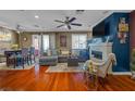 Open-concept living area featuring hardwood floors, a ceiling fan, and a cozy fireplace at 8600 W Charleston Blvd # 2078, Las Vegas, NV 89117