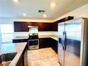 Kitchen featuring stainless steel appliances, granite countertops, and dark wood cabinets at 8694 Glen Echo Ave, Las Vegas, NV 89148