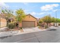 Charming single-story home featuring a two-car garage and well-maintained desert landscaping in front at 8942 Partridge Hill St, Las Vegas, NV 89148