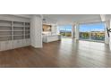 Bright open-concept living space with wood floors, built-in shelving, and a modern kitchen with scenic city views at 9101 Alta Dr # 207, Las Vegas, NV 89145