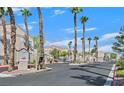 Gated community entrance with palm trees lining the drive and well-maintained landscaping at 9470 Peace Way # 233, Las Vegas, NV 89147