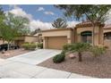 Attractive home with a two-car garage, desert landscaping, and mature trees shading the front at 9533 Yucca Blossom Dr, Las Vegas, NV 89134