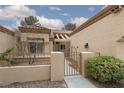 View of the property's gated courtyard with desert landscaping and a tiled roof at 9533 Yucca Blossom Dr, Las Vegas, NV 89134