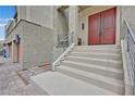 View of the front steps and entryway with red double doors and modern railing at 9830 Wild Coyote Ct, Las Vegas, NV 89141