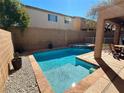 Sparkling pool features a hot tub, set in a private backyard with a covered patio, and a stone retaining wall at 1011 Pecos River Ave, Henderson, NV 89002
