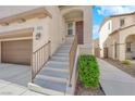 Inviting front entrance with stairs leading to the front door and a view of the attached two-car garage at 10973 Sardinia Sands Dr, Las Vegas, NV 89141