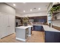 Contemporary kitchen boasts dark cabinets, island with breakfast bar, and stainless appliances at 11334 Colinward Ave, Las Vegas, NV 89135