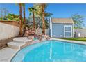 Beautiful pool with a rock waterfall feature and adjacent shed, surrounded by palm trees at 1922 Pyle, Las Vegas, NV 89183