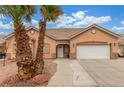 A front exterior of a single-story home featuring desert landscaping and a two-car garage at 209 Eucalyptus Ln, Mesquite, NV 89027