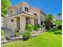 Inviting two-story home with a manicured lawn, a covered front porch, and a two-car garage at 2401 Rice Flower Cir, Las Vegas, NV 89134