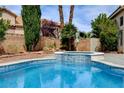Inviting backyard pool and spa with lush landscaping and tranquil privacy wall at 2401 Rice Flower Cir, Las Vegas, NV 89134