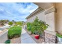 Front porch area featuring stone columns, desert landscaping, and a covered walkway at 2561 Cosmic Dust St, Henderson, NV 89044