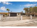Single-story home with desert landscaping protected by a wrought iron fence and concrete posts at 2958 Al De La St, Las Vegas, NV 89146