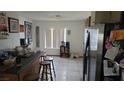 The kitchen features stainless steel appliances, tiled floors, an eat-in counter with barstool seating and a window at 3115 Floral Vista Ave, Henderson, NV 89014