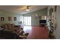 Spacious living room with vaulted ceiling, wood-look floors, a sliding glass door to the back and neutral paint at 3115 Floral Vista Ave, Henderson, NV 89014