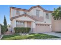 Front exterior of a two-story home featuring a well-kept lawn, garage, and decorative landscape at 319 Fox Lake Ave, Las Vegas, NV 89148