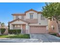 Two story home with a 2 car garage, manicured front yard, and neutral colored stucco exterior at 319 Fox Lake Ave, Las Vegas, NV 89148