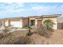 Home featuring a three-car garage, desert landscaping, and tiled roof at 3439 Cottage Canyon St, Laughlin, NV 89029