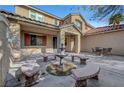 Spacious backyard patio with a fountain, curved benches, and outdoor seating area at 4108 Freel Peak Ct, Las Vegas, NV 89129