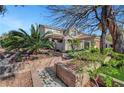 Beautiful two-story house with a lush front yard featuring decorative brick planters and mature trees at 4108 Freel Peak Ct, Las Vegas, NV 89129