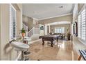 Elegant living room featuring travertine floors, a pool table, and dining area at 4247 Jordanville St, Las Vegas, NV 89129