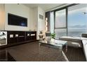 Well-lit living room with a comfortable sectional sofa, city views, and stylish shelving unit at 4381 W Flamingo Rd # 1809, Las Vegas, NV 89103