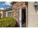 Inviting entryway with a decorative front door, stone accents, and lush landscaping at 5224 E San Palo Dr, Pahrump, NV 89061