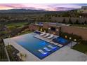 Aerial view of a luxury pool with lounge chairs, a hot tub, and outdoor entertainment area at 535 Serenity Point Dr, Henderson, NV 89012