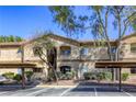 Desert-style condo complex featuring covered parking, stucco exterior, and desert landscaping at 5751 E Hacienda Ave # 243, Las Vegas, NV 89122