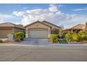 Inviting front exterior featuring a well-manicured lawn, desert landscaping, and a spacious driveway at 6076 Wheat Penny Ave, Las Vegas, NV 89122