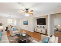 Bright living room featuring hardwood floors, stylish furniture, a ceiling fan, and a mounted flat screen TV at 6076 Wheat Penny Ave, Las Vegas, NV 89122
