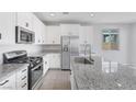 Modern kitchen featuring granite countertops, stainless steel appliances and tiled floor at 6276 Desert Orchid Way, Las Vegas, NV 89141