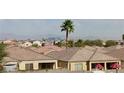A sprawling neighborhood showcases tile roofs, palm trees, and a stunning city skyline in the distance at 6276 Desert Orchid Way, Las Vegas, NV 89141