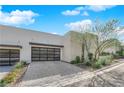 Contemporary house featuring desert landscaping, a textured stone facade, and a multi-car garage at 658 Falcon Summit Ct, Henderson, NV 89012