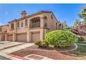 Charming multi-Gathering building showcasing a red tile roof, individual garages and lovely, mature landscaping at 7270 Sheared Cliff Ln # 104, Las Vegas, NV 89149