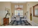 Formal dining area featuring a decorative chandelier, a stylish rug, and ample natural light at 7613 Hackensack Ct, Las Vegas, NV 89128