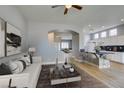 Open concept living room with light wood floors, breakfast bar, and adjacent kitchen at 8232 Sedona Sunset Dr, Las Vegas, NV 89128