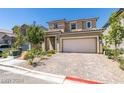 Two-story home featuring a two-car garage and brick paver driveway at 8977 Sweet Chestnut Ln, Las Vegas, NV 89178