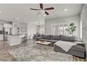 Open-concept living room boasts modern design with sleek ceiling fan and a large comfortable gray sofa at 5742 Shadow Bend Dr, Las Vegas, NV 89135