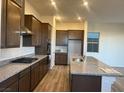 Well-lit kitchen with stainless steel appliances, granite countertops, and wooden floors at 12434 Parkscene Pl, Las Vegas, NV 89138