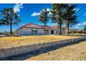 A single-story house with a red tile roof and large windows stands on a sprawling property with mature trees at 1967 N Moapa Valley Blvd, Logandale, NV 89021