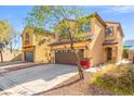 Home exterior featuring desert landscaping, a two-car garage and covered entry way at 1988 Villa De Sol St, Las Vegas, NV 89156