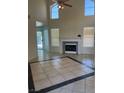 Open living area featuring a tile floor, fireplace, and high ceilings with arched windows at 2211 Arborwood Way, Las Vegas, NV 89142
