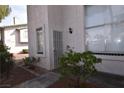 Townhouse front entrance with secure gate, tiled window accents and desert landscaping at 2431 Old Forge Ln # 101, Las Vegas, NV 89121
