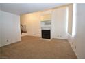 Open-concept living room featuring carpet, a fireplace, and staircase to second level at 2431 Old Forge Ln # 101, Las Vegas, NV 89121
