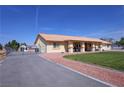 Single-story home with long driveway, partial lawn, and metal gated area at 3110 National Ave, Pahrump, NV 89048