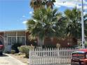 A well-maintained single-story home with desert landscaping, a white picket fence, and a concrete driveway at 3115 Emmons Ave, North Las Vegas, NV 89030